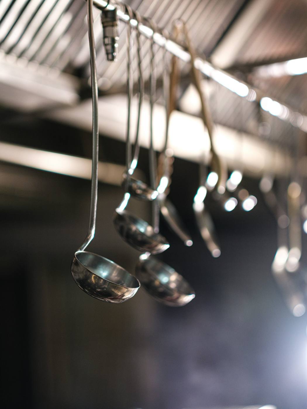 Stainless-steel ladles hanging in a commercial kitchen
